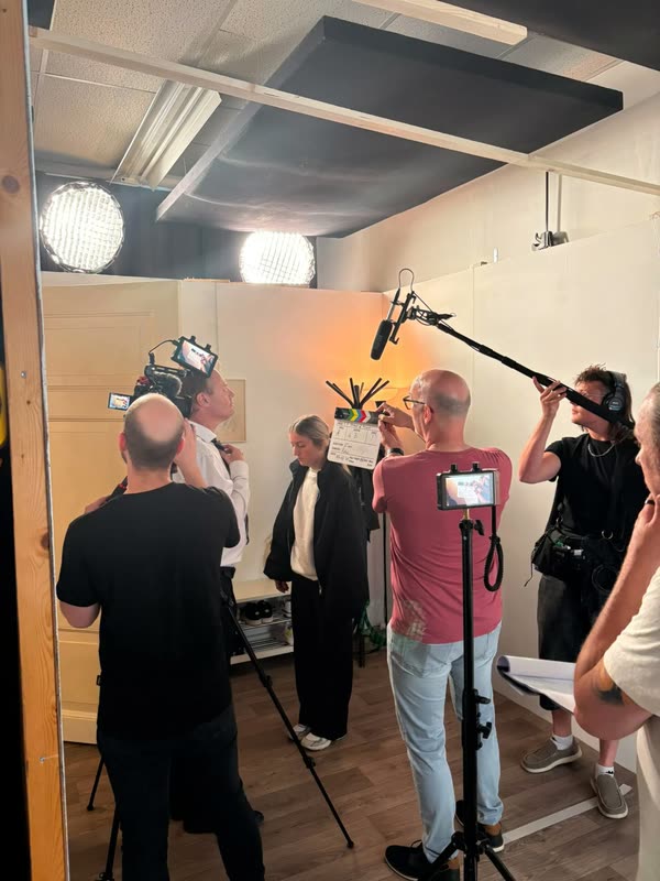 Draaidag op de set: de camera loopt, het klapbord wordt gegeven en de geluidsman houdt de microfoonhengel boven de scène