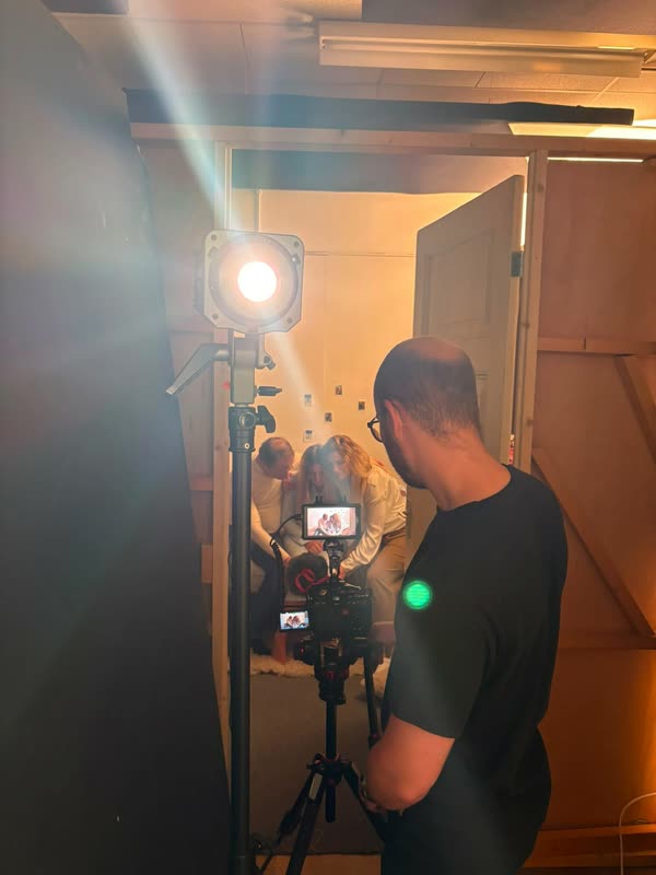 De cameraman filmt vanuit de deuropening een scène in de slaapkamer, met een lamp op de voorgrond