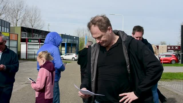Man leest een opdracht, naast hem een meisje met een telefoon